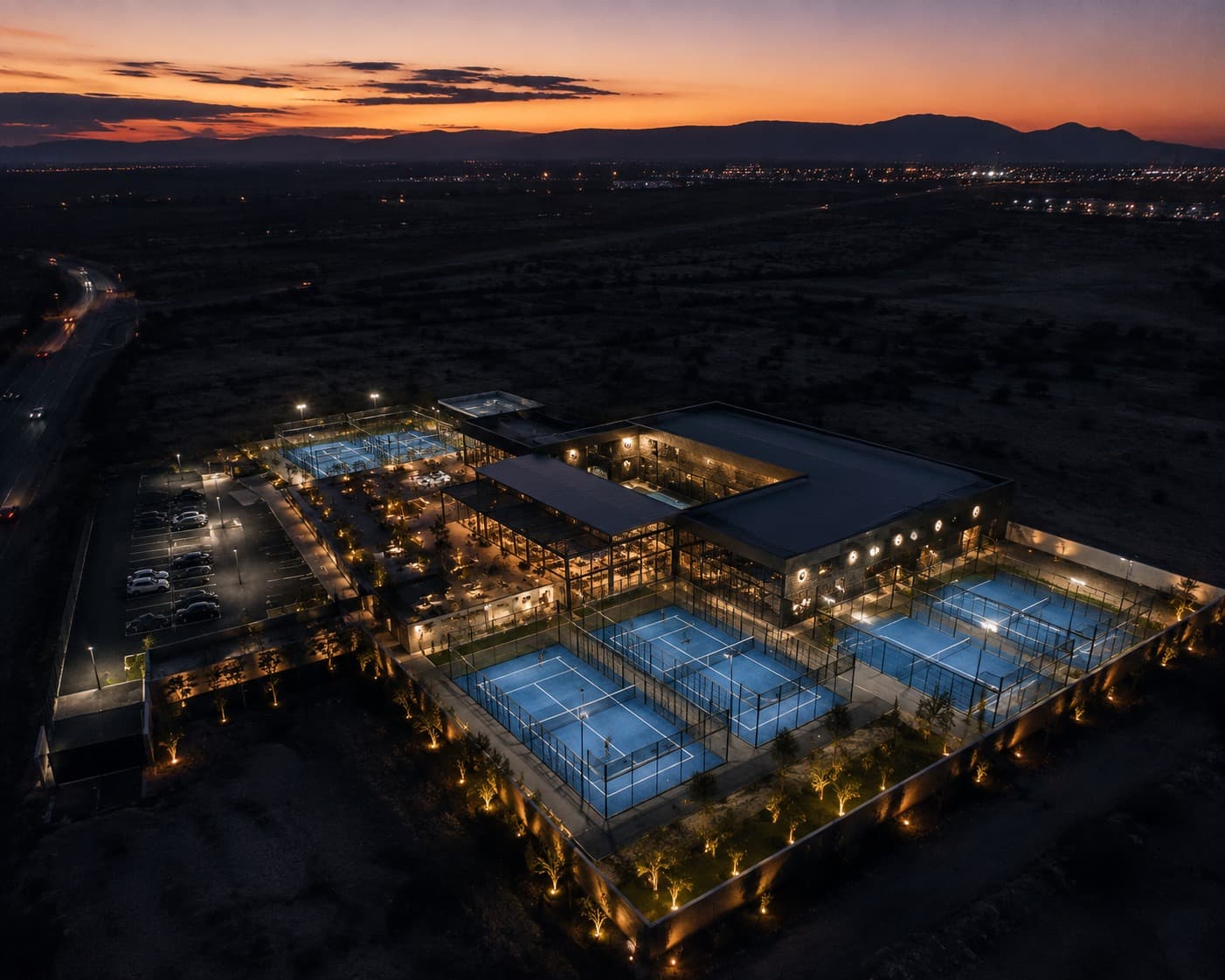 Club de pádel iluminado de noche en la Región Carbonífera, visto desde el aire